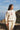 Person wearing a white sweatshirt with "Pretty Girl Motorsports" and dice, standing outdoors with a scenic background.