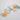 A group of colorful round pin-back buttons scattered on a light gray surface. The buttons feature various slogans in different colors including blue, green, orange, yellow, and red on pastel backgrounds.
